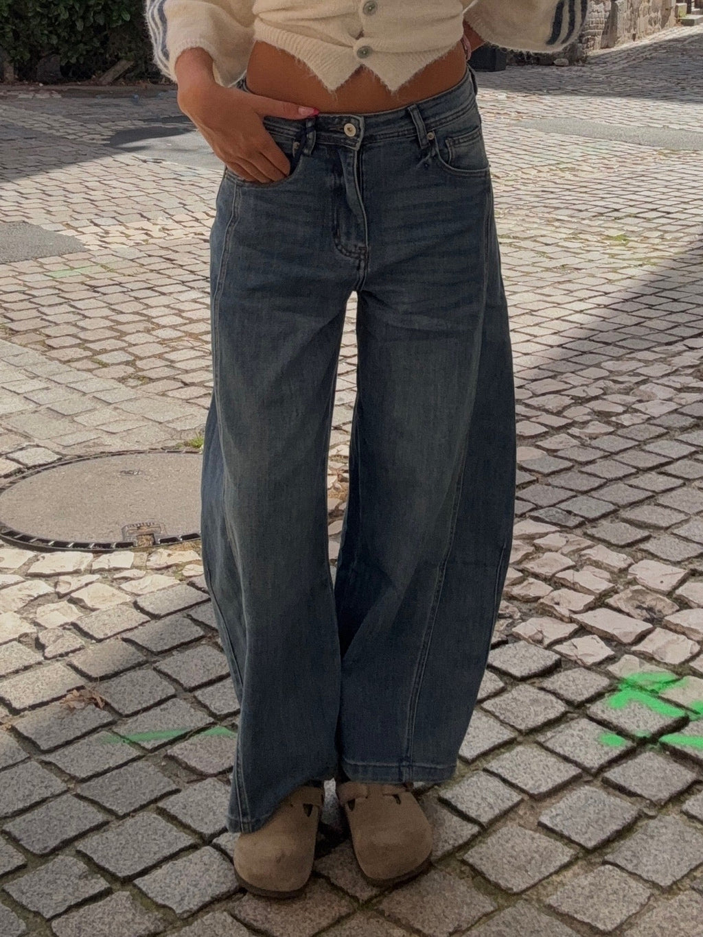 Jean wide leg bleu délavé taille mi-haute, coupe ultra-large, porté avec mules beiges