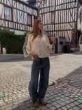 Pull beige avec étoile graphique dans le dos et bandes grises sur les manches