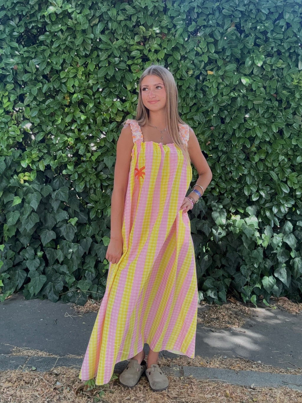Robe longue florale rose et orange portée en extérieur