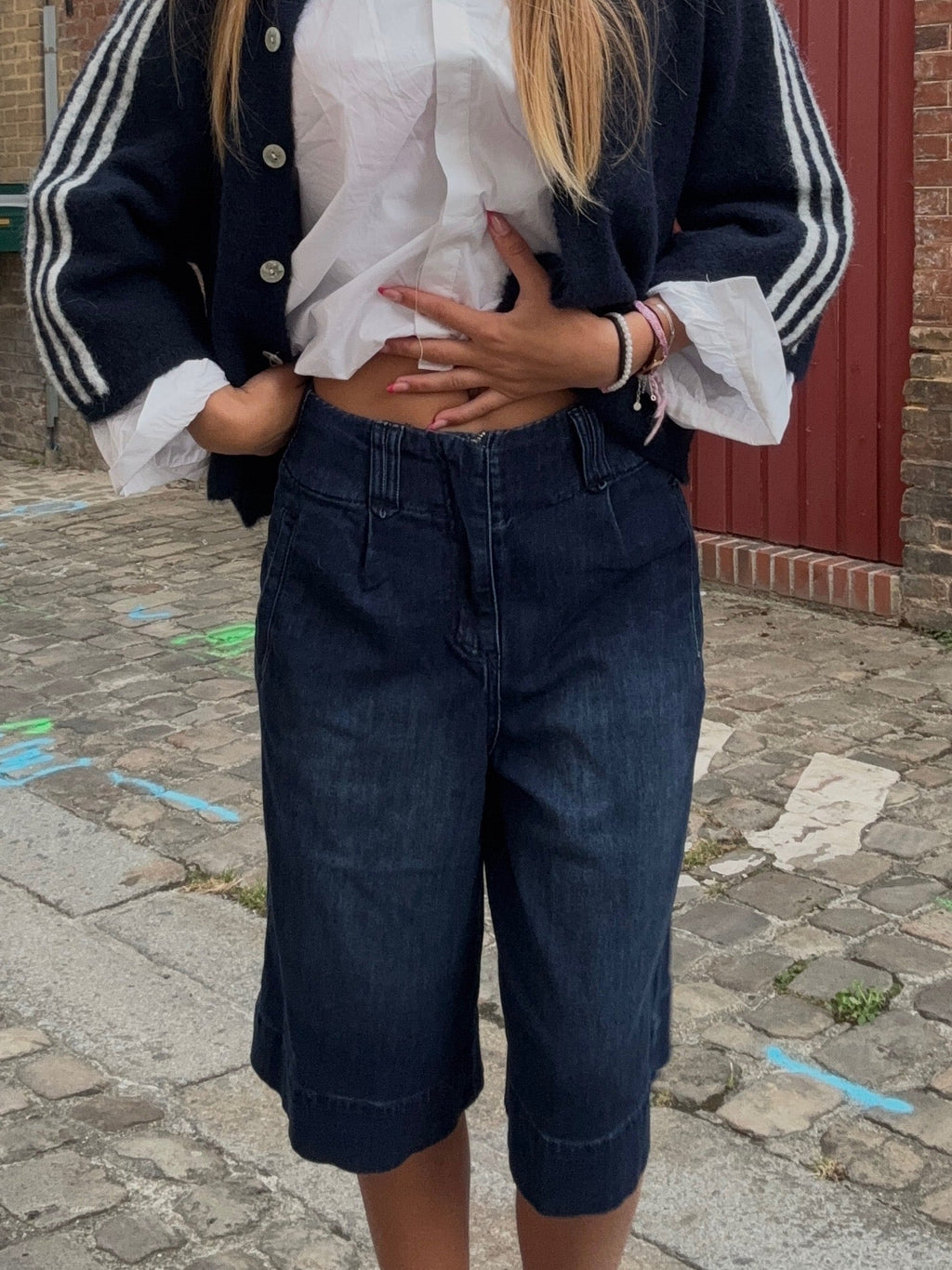 Bermuda jean bleu marine taille haute porté avec cardigan marine et chemise blanche