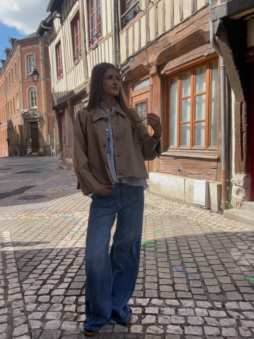 Veste camel oversize portée avec une blouse rayée et un jean wide-leg
