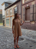 Robe camel courte fluide portée dans une ruelle pavée