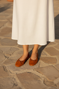Ballerines orange portées — vue plongeante jupe blanche
