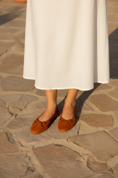 Ballerines orange portées — vue plongeante jupe blanche