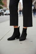 Bottines suède noir bout pointu vue de face fond urbain